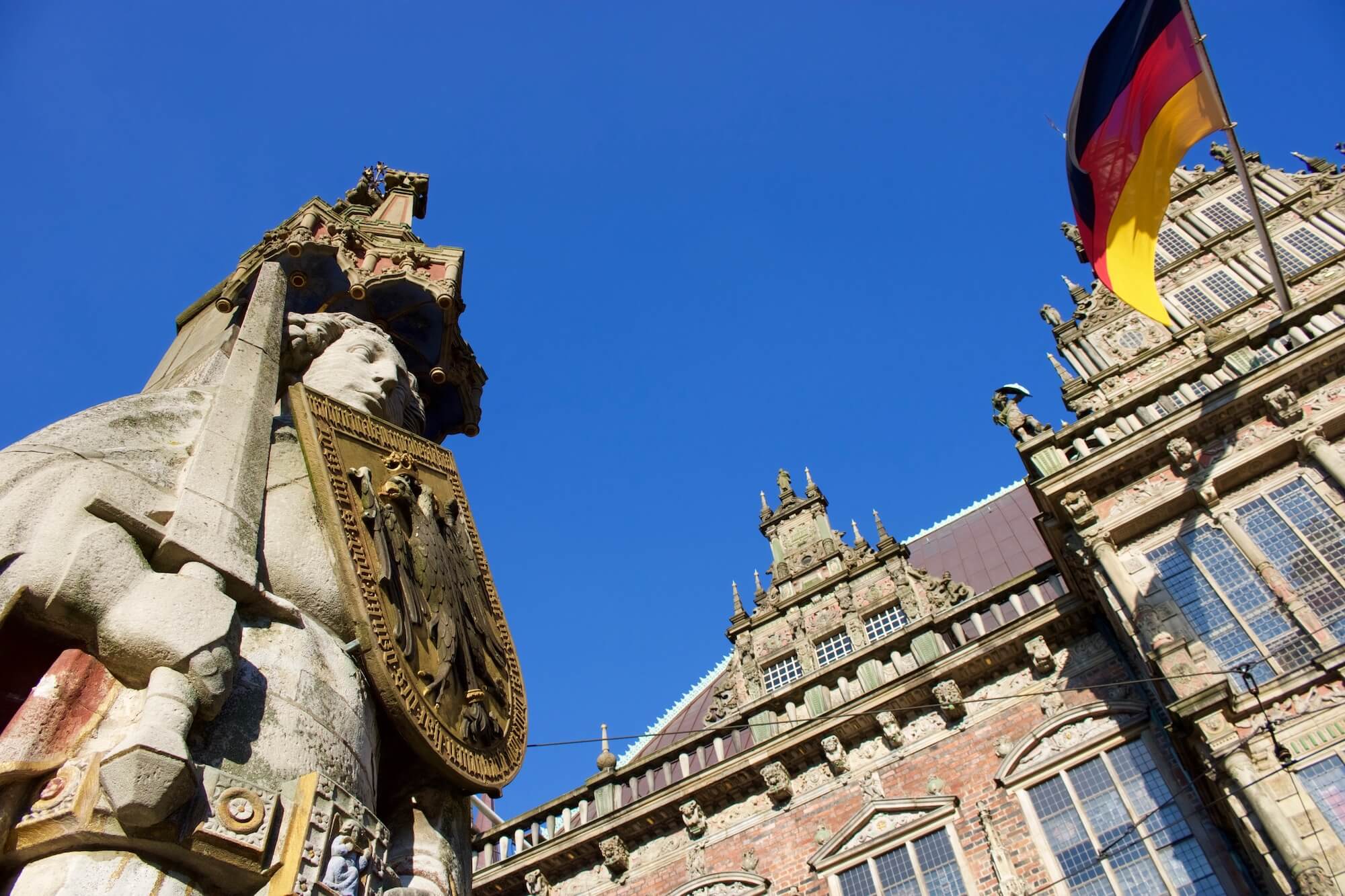 Roland statue and town hall with German flag in Bremen, northern Germany